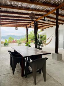 a dining room table and chairs in a room at Casa A la Mar in Zihuatanejo