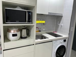 a small kitchen with a microwave and a sink at Yeosu U Bless in Yeosu