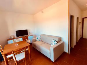 una sala de estar con un sofá y una mesa en Costa Paradiso Villaggio maya GP 2 15 Bilocale vista mare, en Costa Paradiso