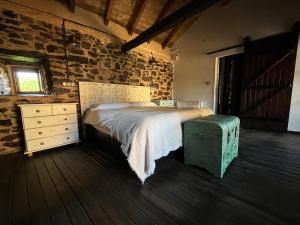 a bedroom with a bed and a brick wall at La Casina de Gelo in Riego de Ambros