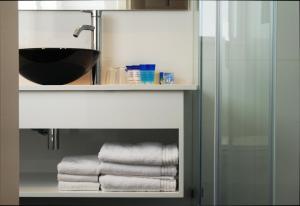 a group of towels on a shelf in a bathroom at Best Western Regency Suites in Tel Aviv