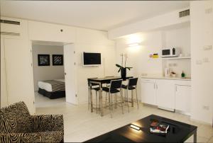 eine Küche und ein Wohnzimmer mit einem Tisch und Stühlen in der Unterkunft Best Western Regency Suites in Tel Aviv