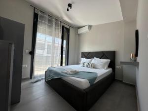 a bedroom with a bed and a large window at Villa Sunset in Yerakiní