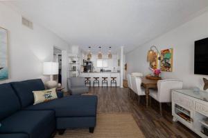 a living room with a blue couch and a kitchen at Beach Blessing - Oceanfront Pool Balcony in North Topsail Beach