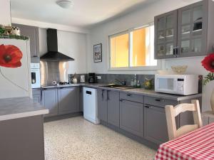 a kitchen with gray cabinets and a white refrigerator at Superbe T3 avec loggias fermées, garage, et wifi à Balaruc-les-Bains, classé 3 étoiles - FR-1-553-216 in Balaruc-les-Bains