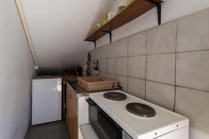 a small kitchen with a stove and a refrigerator at Rooms with a parking space Stari Grad, Hvar - 14831 in Stari Grad