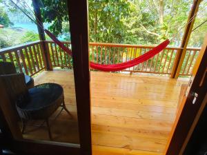 a screened in porch with a hammock on it at Santi Garden Bungalows in Iboih