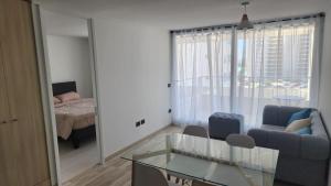 Una sala de estar con un sofá y una mesa de cristal. en Laguna del mar, La Serena, en La Serena