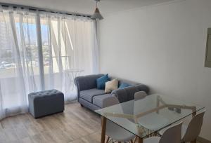 Una sala de estar con un sofá y una mesa de cristal. en Laguna del mar, La Serena, en La Serena