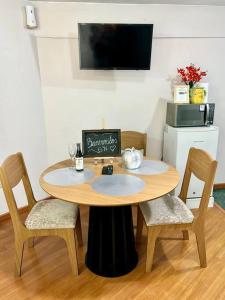 a wooden table with chairs and a table with a sign on it at Gaby's suite in Quito