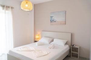 um quarto branco com uma cama com almofadas brancas em Koks’ Guesthouse em Himare