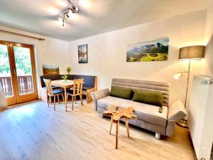 a living room with a couch and a table at Ferienwohnungen Jagerer in Ramsau +25 photos