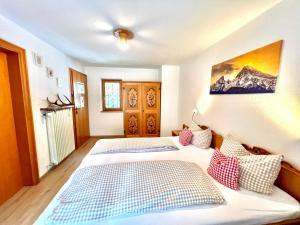 a bedroom with two beds and a painting on the wall at Ferienwohnungen Jagerer in Ramsau