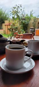 eine Tasse Kaffee auf einem Teller auf einem Tisch in der Unterkunft Posada Rivera in San Salvador de Jujuy