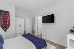 a bedroom with a bed and a flat screen tv at Vermithor's Bronze Ember Sweet Suite in Seattle