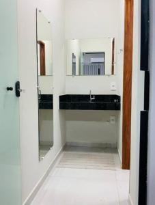 a bathroom with a mirror and a sink at Suíte confortável no centro in Delfinópolis