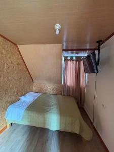 a small bedroom with a bed and a television at Hospedaje Jireh in Oxapampa