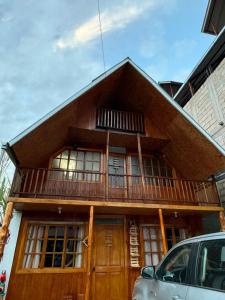 a house with a balcony on top of it at Hospedaje Jireh in Oxapampa