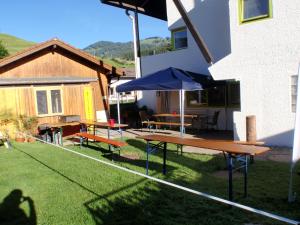 Una mesa de picnic y una sombrilla en un patio. en Outdoor Zentrum Allgäu- Hostel, en Bihlerdorf