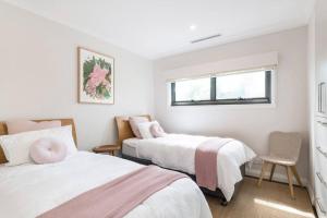 a bedroom with two beds and a window at Island Style - By Betina King in Scotland Island