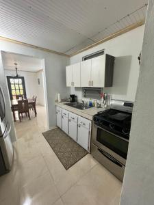 a kitchen with white cabinets and a stove top oven at Hacienda Bella Vista in Limones