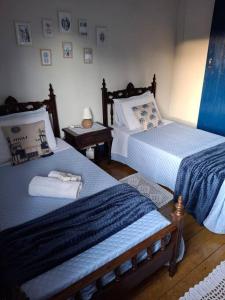 una camera da letto con due letti e un tavolo con una lampada di Casa Coronel Estevão a Santo Antônio do Jardim