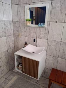 un bagno con un lavandino bianco e uno specchio di Casa Coronel Estevão a Santo Antônio do Jardim