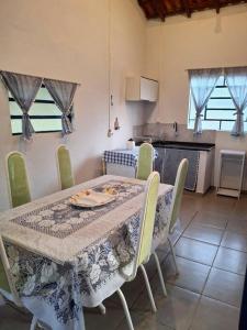 tavolo da pranzo con sedie e tavolo e cucina di Casa Coronel Estevão a Santo Antônio do Jardim