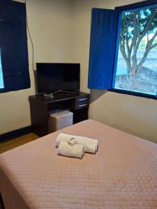 una camera da letto con un letto con due asciugamani sopra di Casa Coronel Estevão a Santo Antônio do Jardim