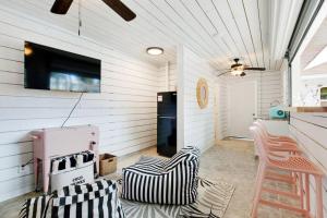Habitación con cocina con nevera y sillas. en Salt Gypsy Unit A Expansive Outdoor Space w Pool, en Tybee Island