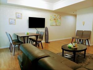 a living room with a couch and a table and a tv at Davao Central Suites in Davao City