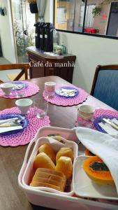 a table with a tray of food on a table at Maga hospedagem in Penha