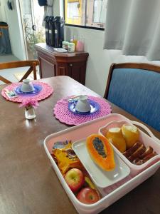 a tray of food sitting on a table with fruit at Maga hospedagem in Penha