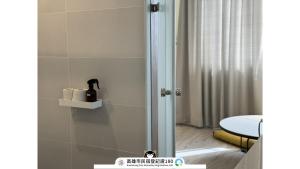 un bagno con doccia con porta in vetro di Yi Hostel a Kaohsiung