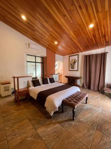 a bedroom with a large bed and a wooden ceiling at Hotel & Balneario Los Angeles in Taxco de Alarcón
