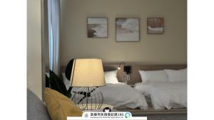 una camera da letto con un letto e un tavolo con una lampada di Yi Hostel a Kaohsiung