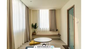un soggiorno con un tavolo e una finestra di Yi Hostel a Kaohsiung
