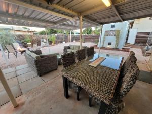 a patio with a table and chairs and an umbrella at 16 Stokes-Hughes Street - With Pool in Exmouth
