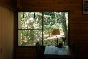 een raam in een hut met een tafel en een lamp bij rinne 2nd living Sauna Villa Nasu in Nasu