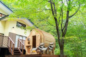 een houten huis met stoelen op een terras bij rinne 2nd living Sauna Villa Nasu in Nasu
