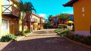 a cobblestone street between two buildings with palm trees at Casa Aconchego in Búzios