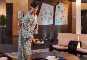 a woman in a kimono standing in a room at Park Hotel Tokyo in Tokyo