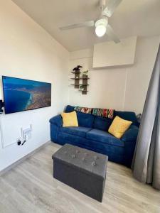 a living room with a blue couch and a table at Elegant Coastal Studio in Bucerías