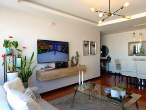 a living room with a flat screen tv on a wall at LIKE a HOME, 3Beds - Balcony - Garage - 6ThFloor in Quito