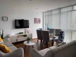 un salon avec un canapé, des chaises et une télévision dans l'établissement Siéntete un turista como en casa DPTO 100 m2, à Lima