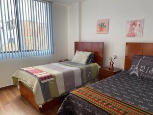 une chambre avec deux lits et une fenêtre dans l'établissement Siéntete un turista como en casa DPTO 100 m2, à Lima