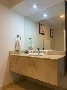 a bathroom with a sink and a large mirror at Villa Magna in Nuevo Vallarta