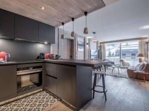 谷雪维尔Appartement au centre de Courchevel 1550, 6/7 pers, Wi-Fi, parking, accès spa - FR-1-631-198的配有黑色橱柜和台面的厨房