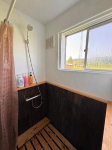 a bathroom with a shower and a window at TOTONOU Place in Asahikawa