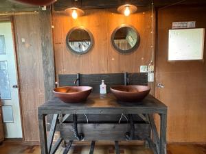 two wooden bowls sitting on a table in a bathroom at TOTONOU Place in Asahikawa